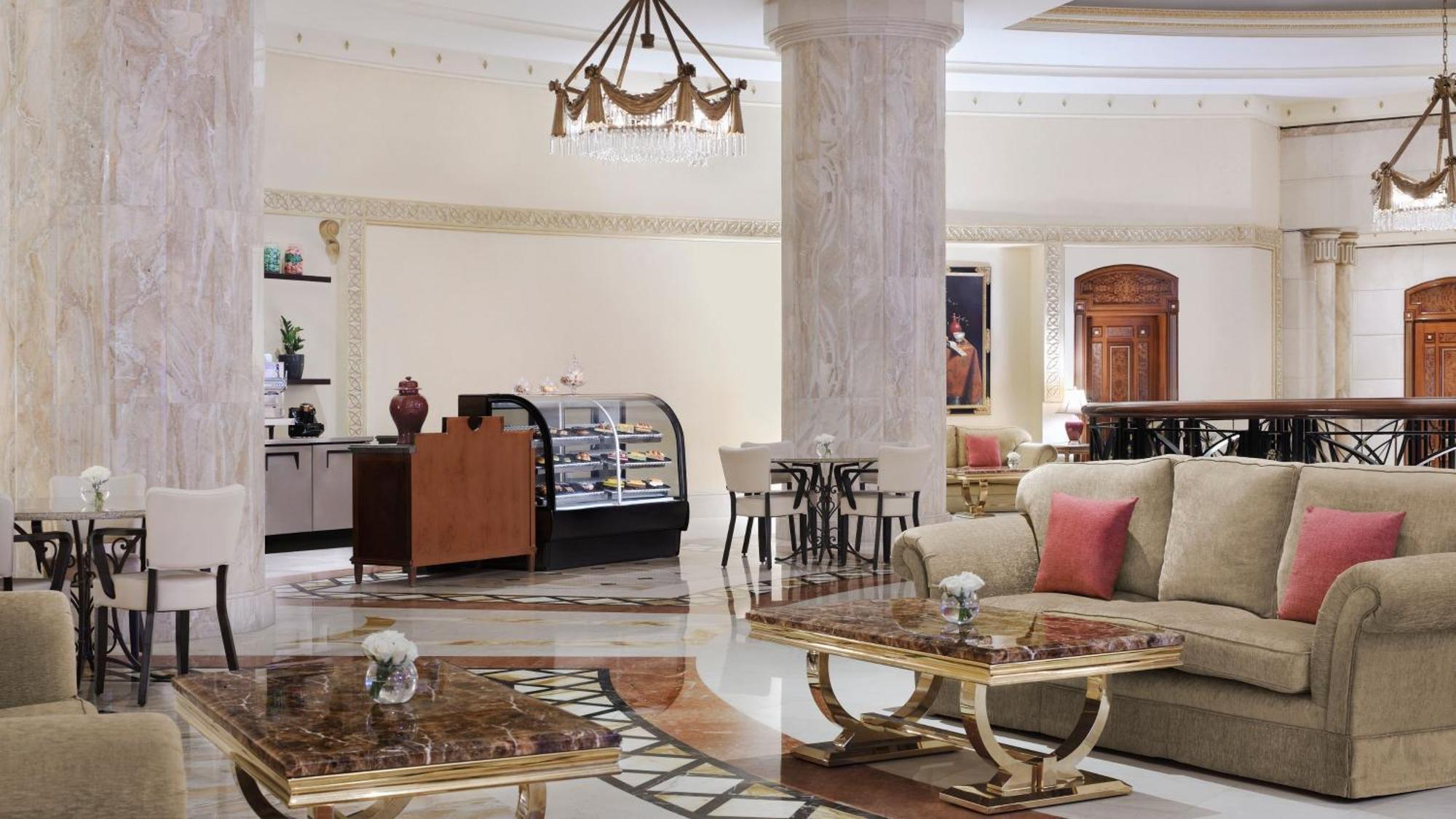 Hotel Intercontinental Dar Al Iman Madinah By Ihg Medina Esterno foto The photo shows a luxurious hotel lobby or lounge area. It features elegant marble floors and tall columns. There are comfortable seating arrangements with a sofa and stylish tables that have marble tops. A display case for pastries or refreshments i