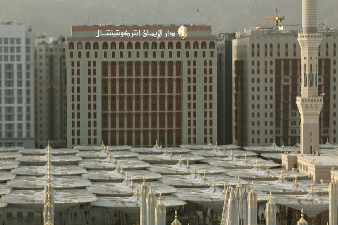 Hotel Intercontinental Dar Al Iman Madinah By Ihg Medina Esterno foto The photo shows a view of a large building with a modern architectural design, which appears to be a hotel or a commercial establishment. In front of the building, there are several large white canopies that provide shade, likely in a public space or